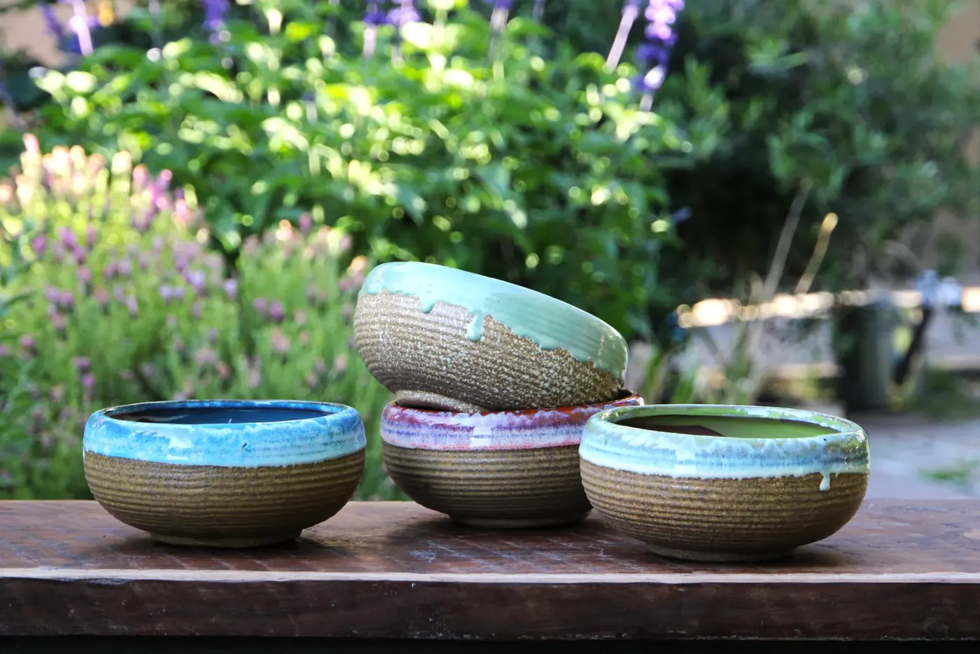 Shallow glazed bowls in blue and green on a nursery table